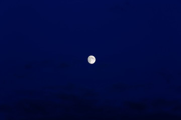 Naklejka na ściany i meble Gorgeous bright moon and few clouds on dark blue night sky. Amazing nature background.