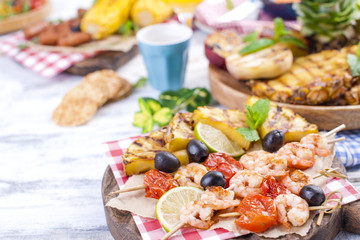 Vegetables, fruits and shrimp on the grill, for a summer lunch. Healthy food. Appetizers on a white background. Copy space.