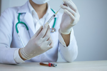 Doctor holding medical injection syringe and stethoscope