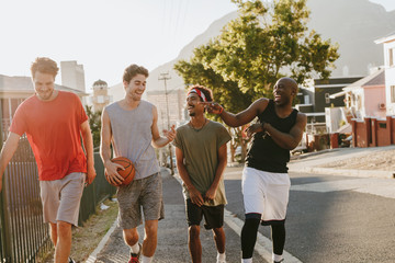 Obraz premium Basketball guys walking on pavement with the ball