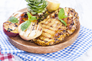 Fruits, anas and peaches on the grill, for a summer lunch. Healthy food. Appetizers on a white background. Copy space.