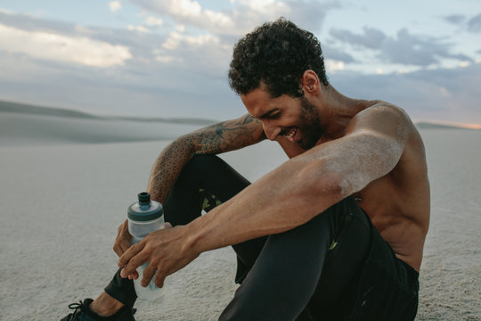 Man relaxing after exercising in desert