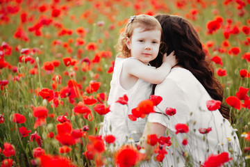 Obraz na płótnie Canvas mother and daughter playing in flower field