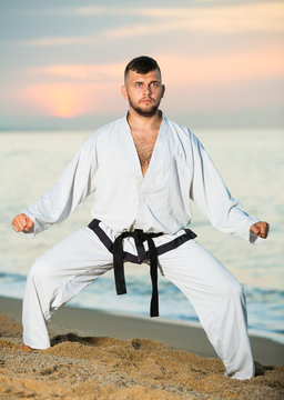 Nice man doing karate at ocean quay