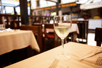 The glass of white wine in street cafe. Space for text