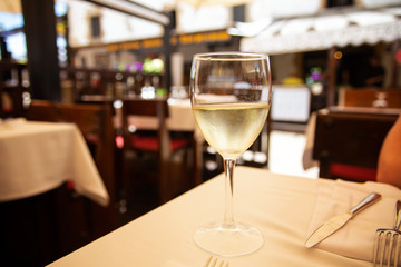 The glass of white wine in street cafe. Space for text