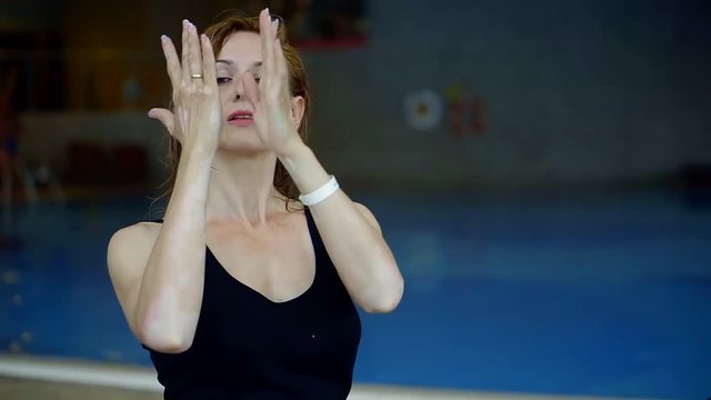 pretty adult woman with vitiligo is posing, crossing hands in front of face and looking on her skin