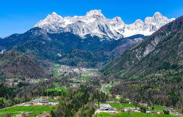Fototapeta na wymiar Village and snowy mountains in the Dolomites, Italy