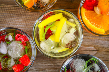 Various detox water in glasses, different tastes, berries, fruits.