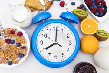 Fototapeta na wymiar breakfast time, alarm clock and healthy and balanced breakfast