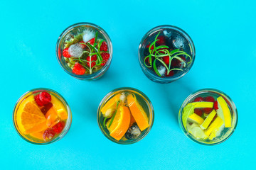 Various detox water in glasses, different tastes, berries, fruits.
