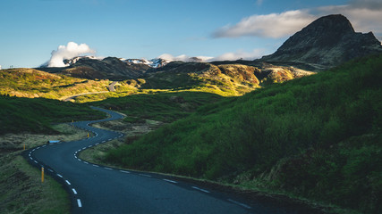 Beautiful mountain road in iceland during sunset with many curves, sunny scenery