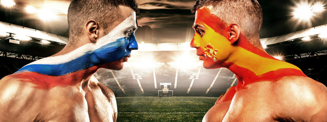 Russia vs Spain. Two soccer or football fans with flags face to face on stadium.