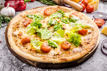 Homemade Vegan pizza with fresh vegetables and pesto, gray stone background, copy space, restaurant menu concept. Italian food style, close up.