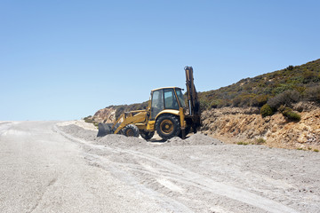 A bulldozer in the making of a road in a construction site