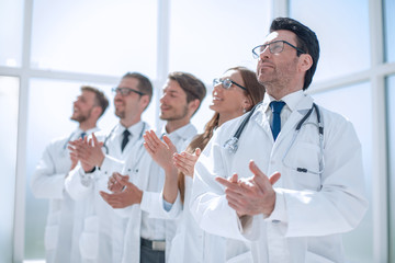 group of doctors applauds, standing in the hospital