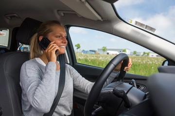 Junge Frau telefoniert beim Autofahren