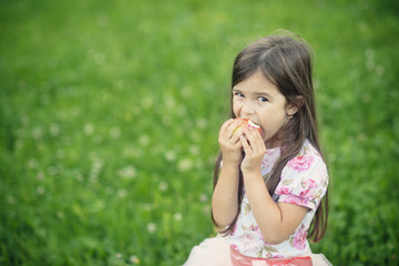 Little girl eats apple