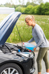 Junge Frau füllt bei ihrem PKW Scheibenreiniger nach