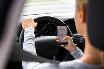 Junge Frau schreibt während der Autofahrt eine SMS