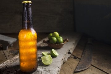 chill beer and lemons on a rustic wood table, machete, mexico