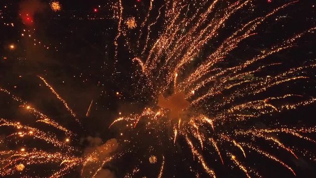 Bright firework explosion in the night sky. Fireworks salute with the black sky background. New years fireworks. Celebrating the Independence Day. Colorful burst of fireworks.