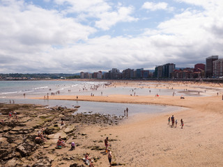 Fototapeta na wymiar Summer holidays in Gijón (Asturias, north of Spain). San Lorenzo beach view.
