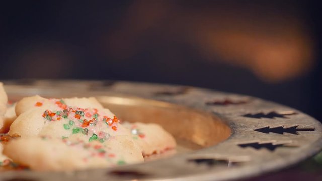 Plate of Christmas cookies left out for Santa Claus by a fireplace in 4k. Fire flickers behind the traditional holiday baked goods put out for St. Nick on Christmas Eve. 
