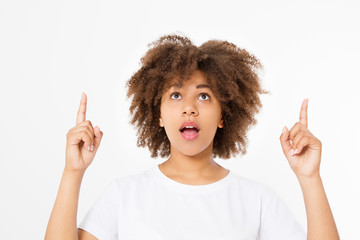 Happy suprised face. Young dark skin woman pointing up isolated on white background in tshirt...