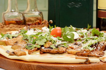 Pizza with bacon, mushrooms and arugula