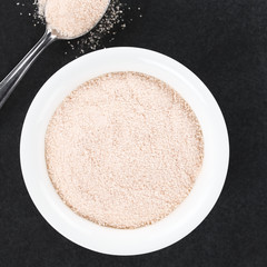 Orange juice powder in small bowl, photographed overhead on slate (Selective Focus, Focus on the powder in the bowl)