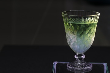 Close up transparency apple juice in crystal glass on black background