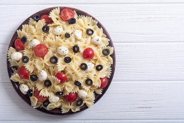 Pasta salad with mozzarella , olives and tomatoes