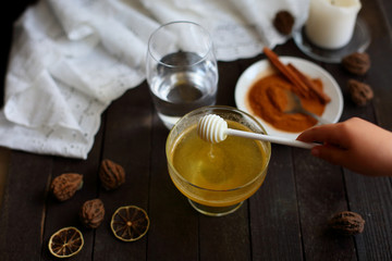 honey and cinnamon on dark wooden background
