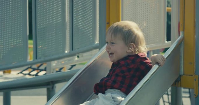 Little toddler boy on slide