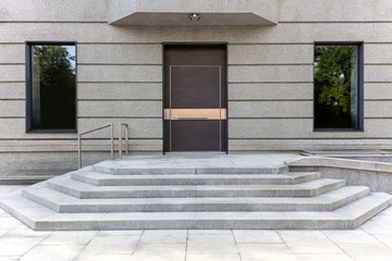 closed metal front door with gray stone door steps