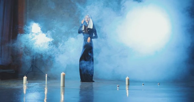 Sexy nun posing in a smoke studio