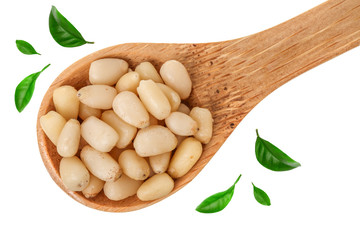 Shelled cedar pine nuts in wooden spoon isolated on white background. Top view. Flat lay