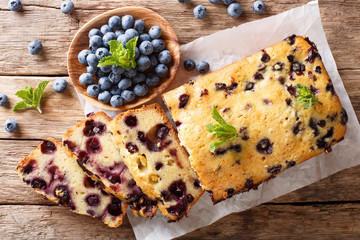 Dessert sliced fresh blueberry bread muffin cake with mint closeup. horizontal top view