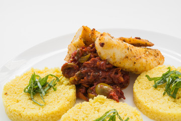 жаренная курица с острым соусом и кашей на белой тарелке.