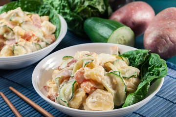 Delicious potato salad with ham, egg and cucumber