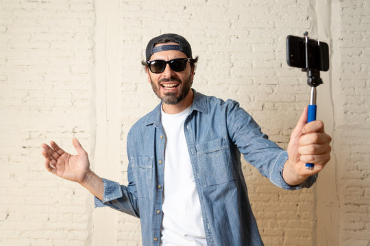 young attractive latin man taking a selfie with his smart cell phone.