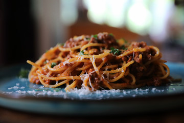 spaghetti Bolognese with minced beef and tomato sauce garnished with parmesan cheese and basil , Italian food