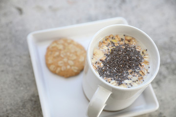 Cereal on milk in cup with woman hand breakfast