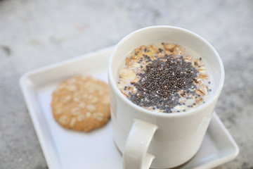 Cereal on milk in cup with woman hand breakfast