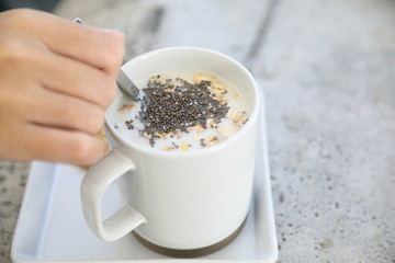 Cereal on milk in cup with woman hand breakfast