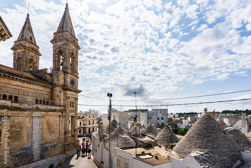 Wall mural cityscape of alberobello with the church of saint cosma and daminano and the trulli houses, apulia, 