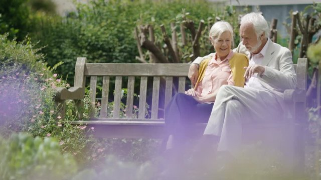 Senior couple sitting on a bench having a conversation