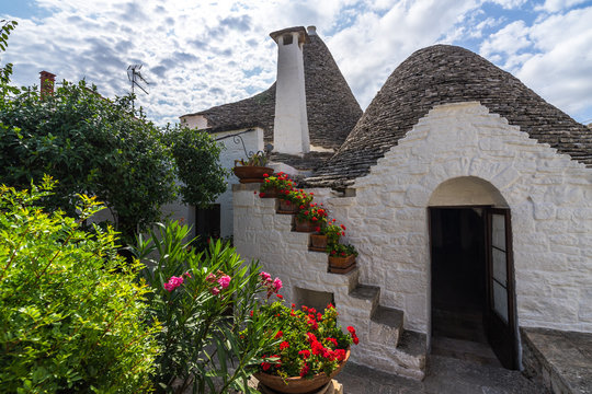 Lively garden on the back of the Trullo Sovrano, the biggest trullo house in Alberobello, Apulia, Italy