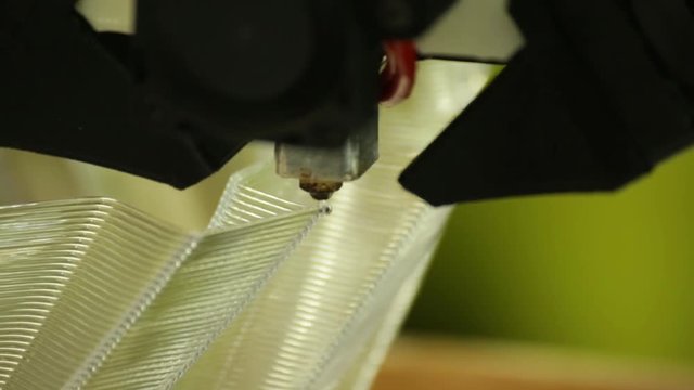 A 3d printing head/nozzle precisely lays down the next layer of a build